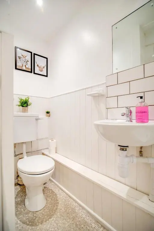 a white bathroom with a toilet and a sink at Comfortable 2-Bedroom Inverness Flat in Inverness