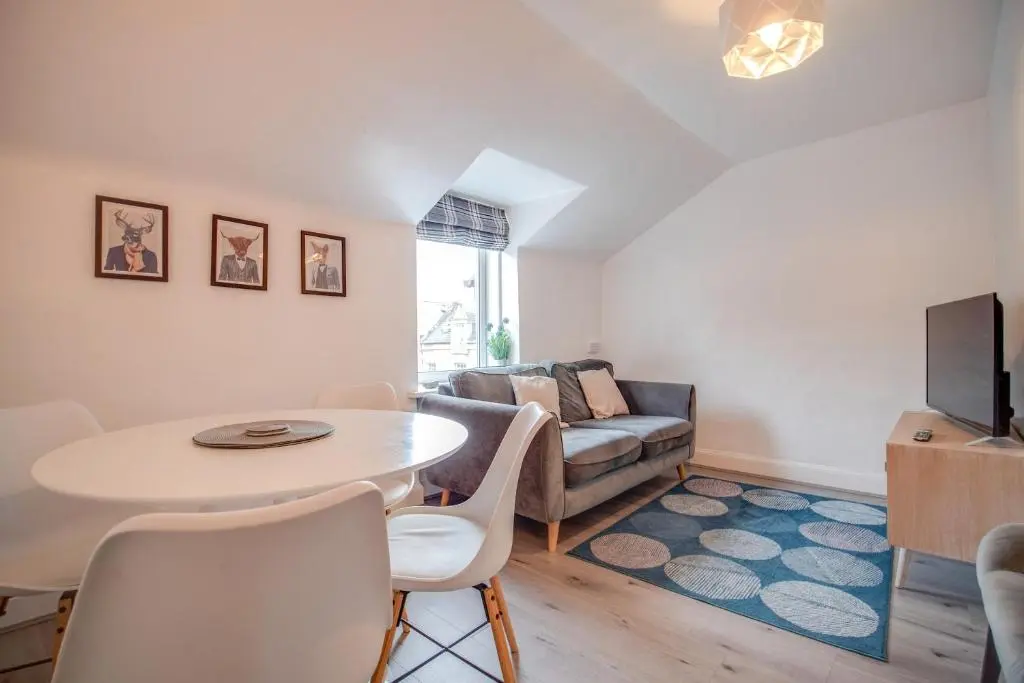 a living room with a table and a couch at Comfortable 2-Bedroom Inverness Flat in Inverness