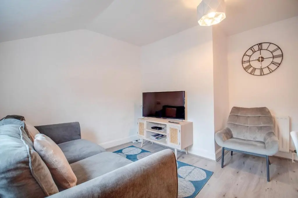 a living room with a couch and a tv and a chair at Comfortable 2-Bedroom Inverness Flat in Inverness