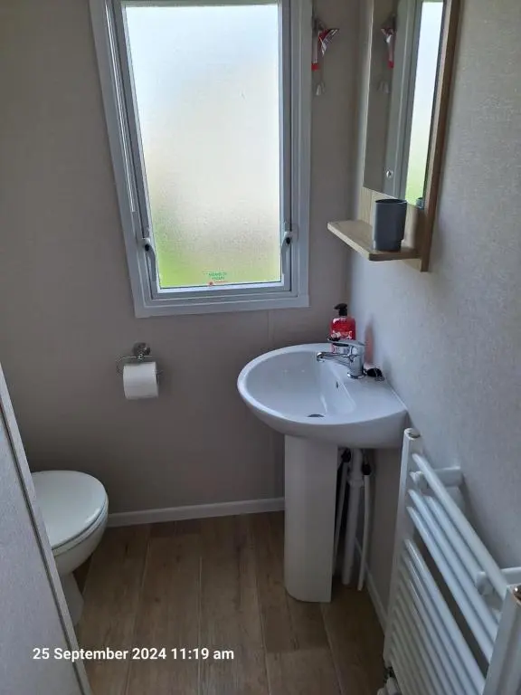 a bathroom with a sink and a toilet and a window at Lewis Sands PC114 in Lossiemouth