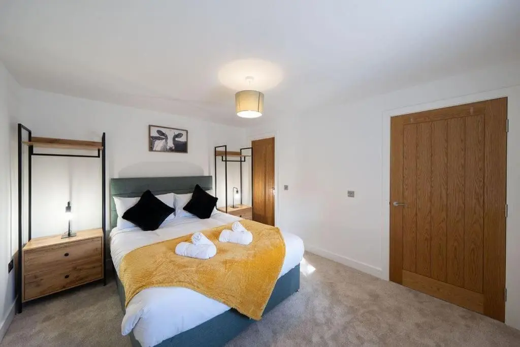 a bedroom with a large bed with two towels at Easter Cottage -4 Bed Converted Barn Cottage in Turriff