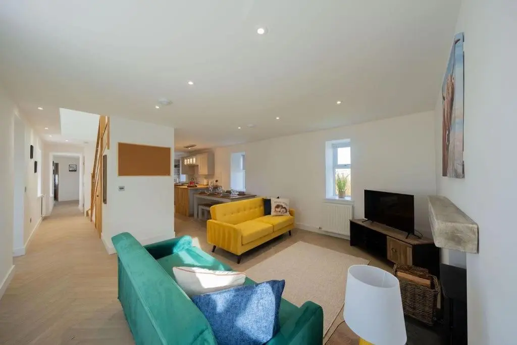 a living room with a green couch and a yellow chair at Easter Cottage -4 Bed Converted Barn Cottage in Turriff