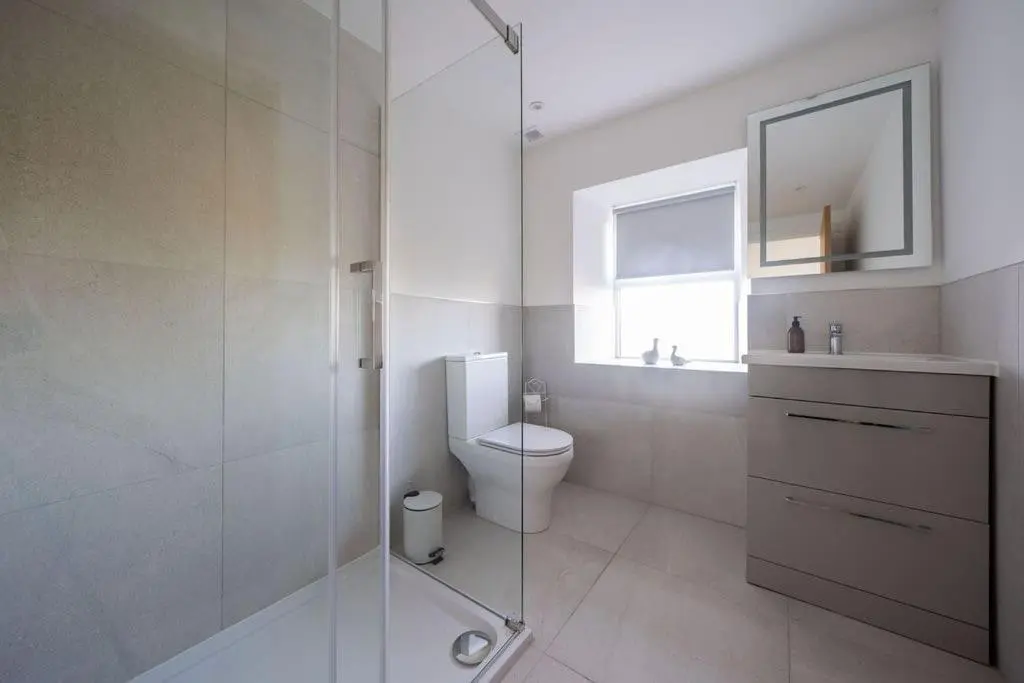 a bathroom with a toilet and a glass shower at Easter Cottage -4 Bed Converted Barn Cottage in Turriff