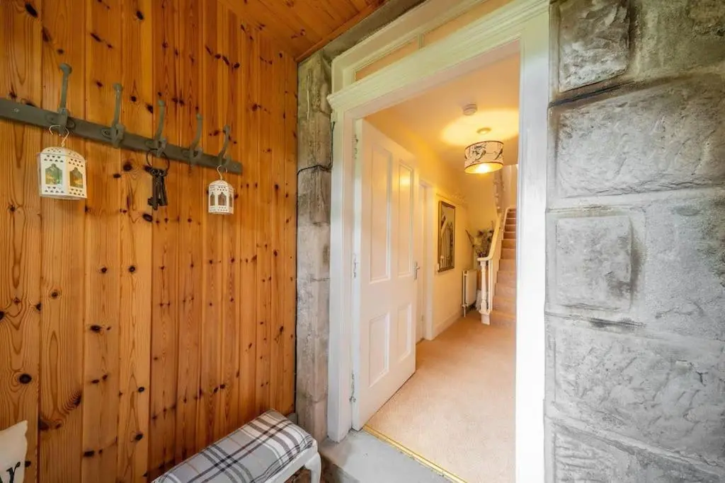 a hallway of a house with wooden walls and a door at Red Squirrel Cottage, Family & Pet Friendly Adventure Retreat, Strathdon, Aberdeenshire in Towie