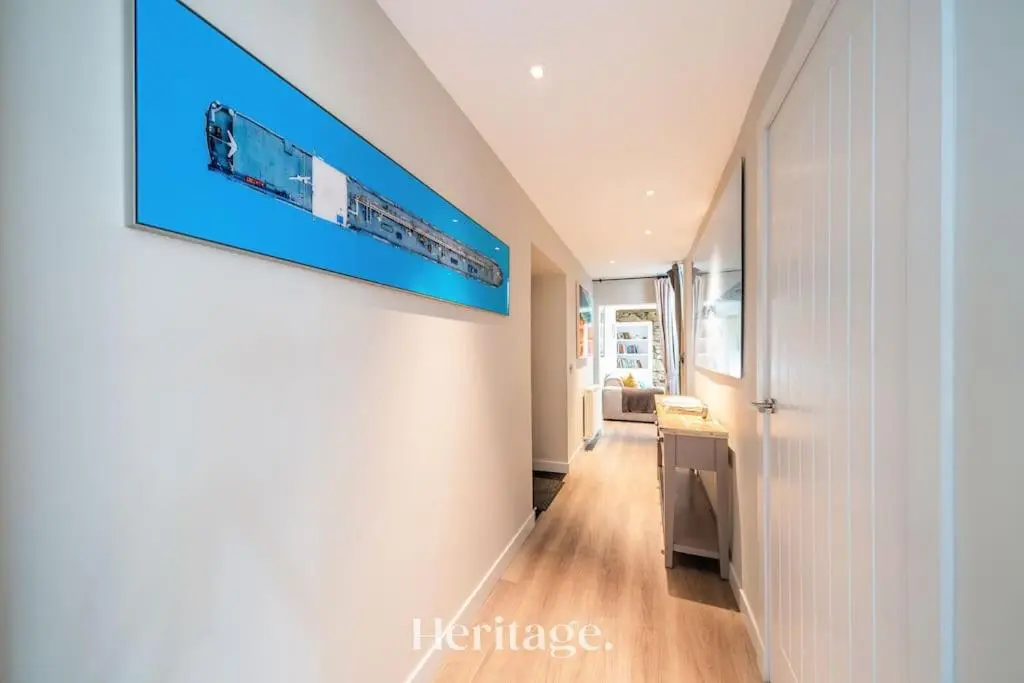 a hallway with a television on a wall at Beach Cottage, Pet & Family Friendly Stay in Moray in Lossiemouth