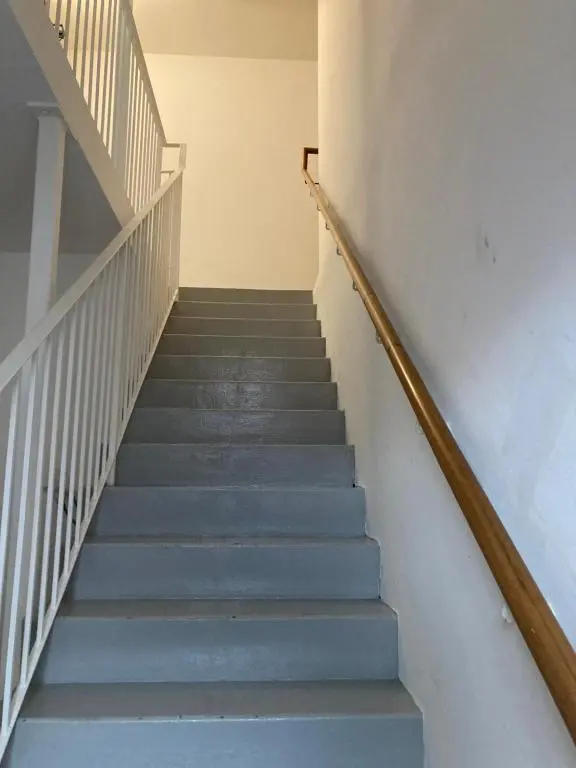 a stairway with blue stairs and white walls at Flat 2 at Inverness City in Inverness