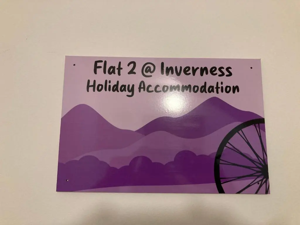 a sign hanging on a wall with a wheel at Flat 2 at Inverness City in Inverness
