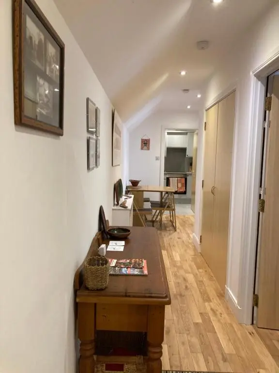 a living room with a wooden table and a hallway at Flat 2 at Inverness City in Inverness