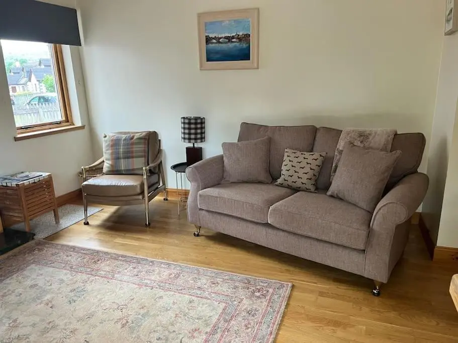 a living room with a couch and a chair at Dalfaber House Luxury holidays in the Highlands in Aviemore