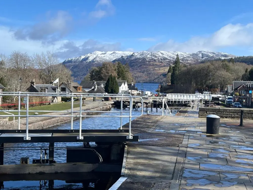a bridge over a river with mountains in the background at Old Lock-keeper's Cottage in Fort Augustus