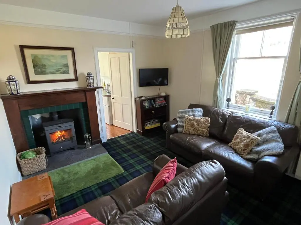 a living room with a couch and a fireplace at Old Lock-keeper's Cottage in Fort Augustus