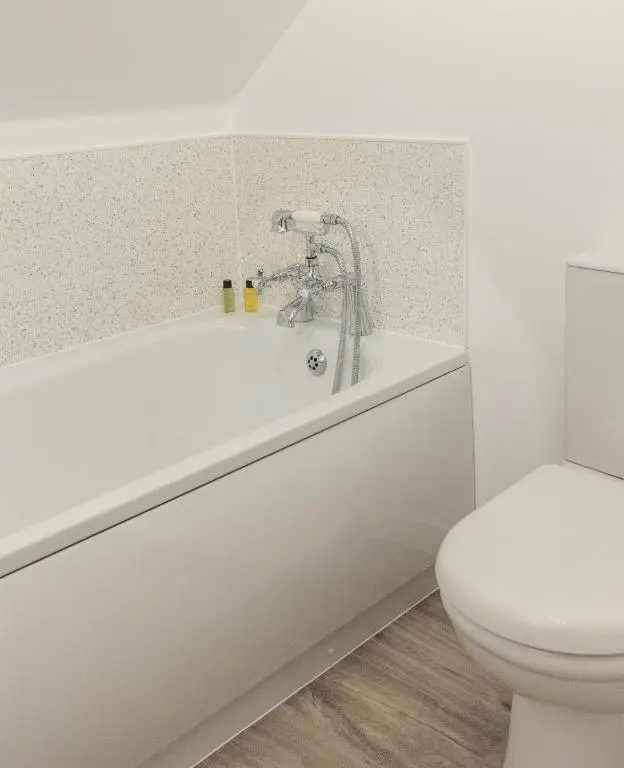 a bathroom with a tub and a toilet at Dalvey Abbotshill Farm House in Forres