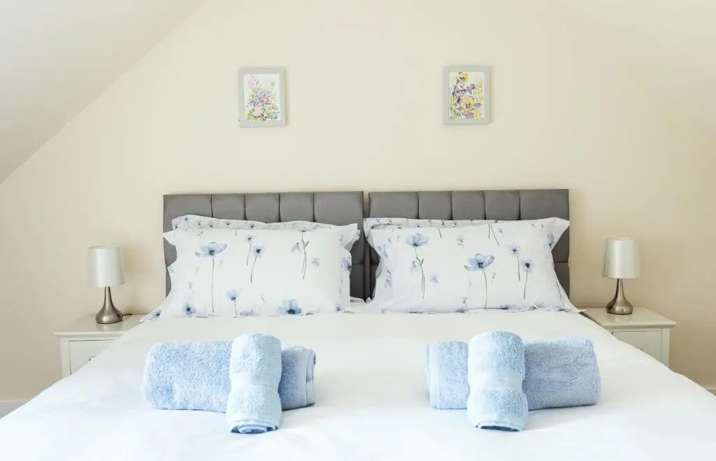 a bedroom with a bed with blue towels on it at Dalvey Abbotshill Farm House in Forres