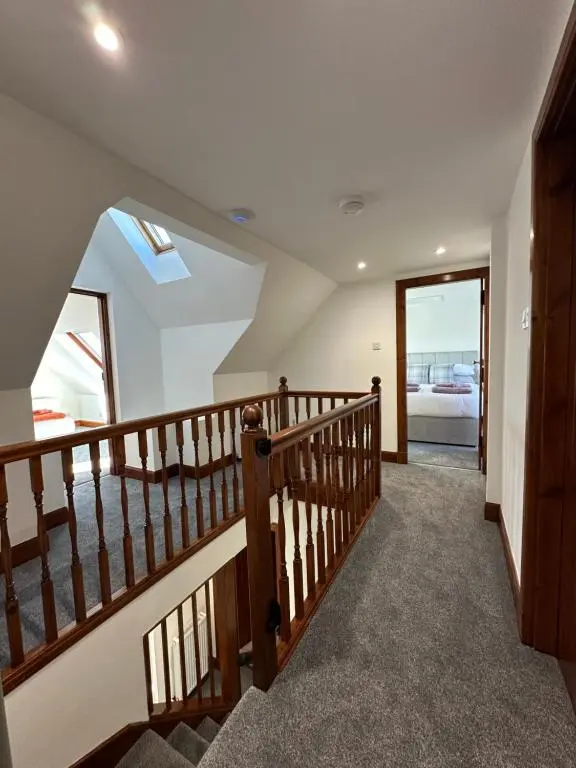 a staircase in a house with a stair case at Stunning Country Cottage in Ardross Close To Traitors Castle & NC500 in Boath
