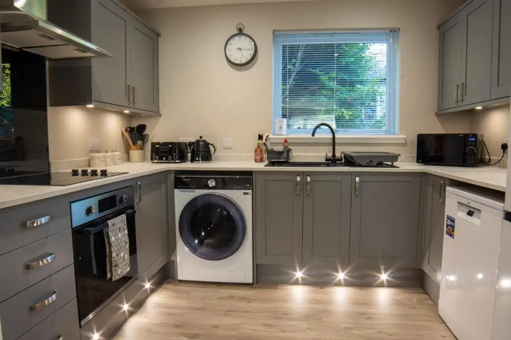 a kitchen with a washing machine and a sink at Stunning Country Cottage in Ardross Close To Traitors Castle & NC500 in Boath