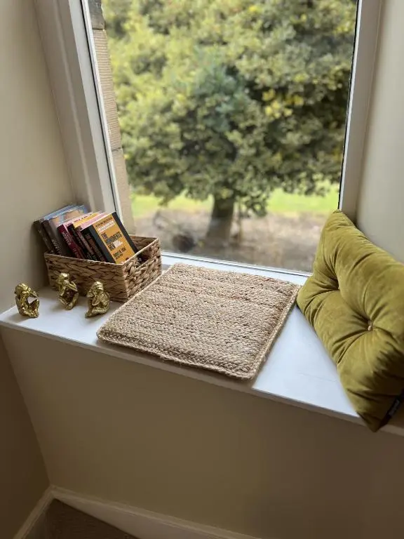 a window sill with a basket of books and a pillow at No. Ten Guesthouse in Tain