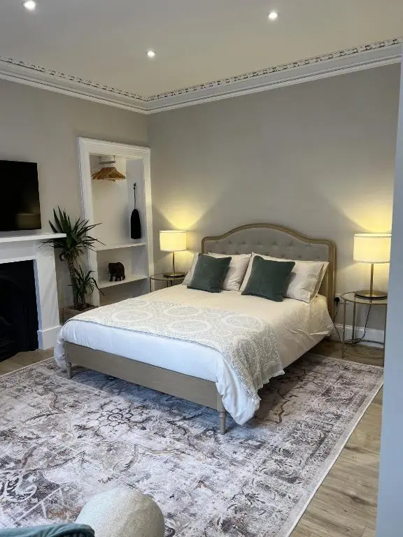a bedroom with a large bed and a fireplace at No. Ten Guesthouse in Tain