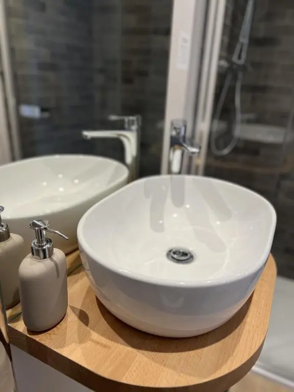 a bathroom with a white sink on a wooden counter at No. Ten Guesthouse in Tain
