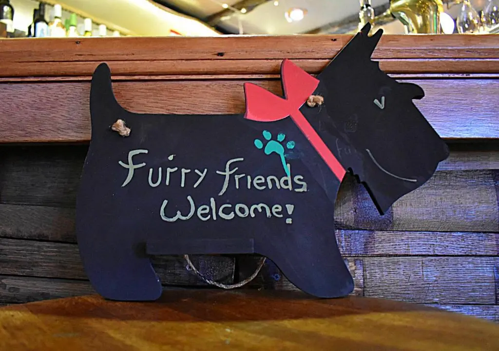 a black dog sign with the words furry friends welcome at The Garden Arms Pub and Rooms in Gardenstown