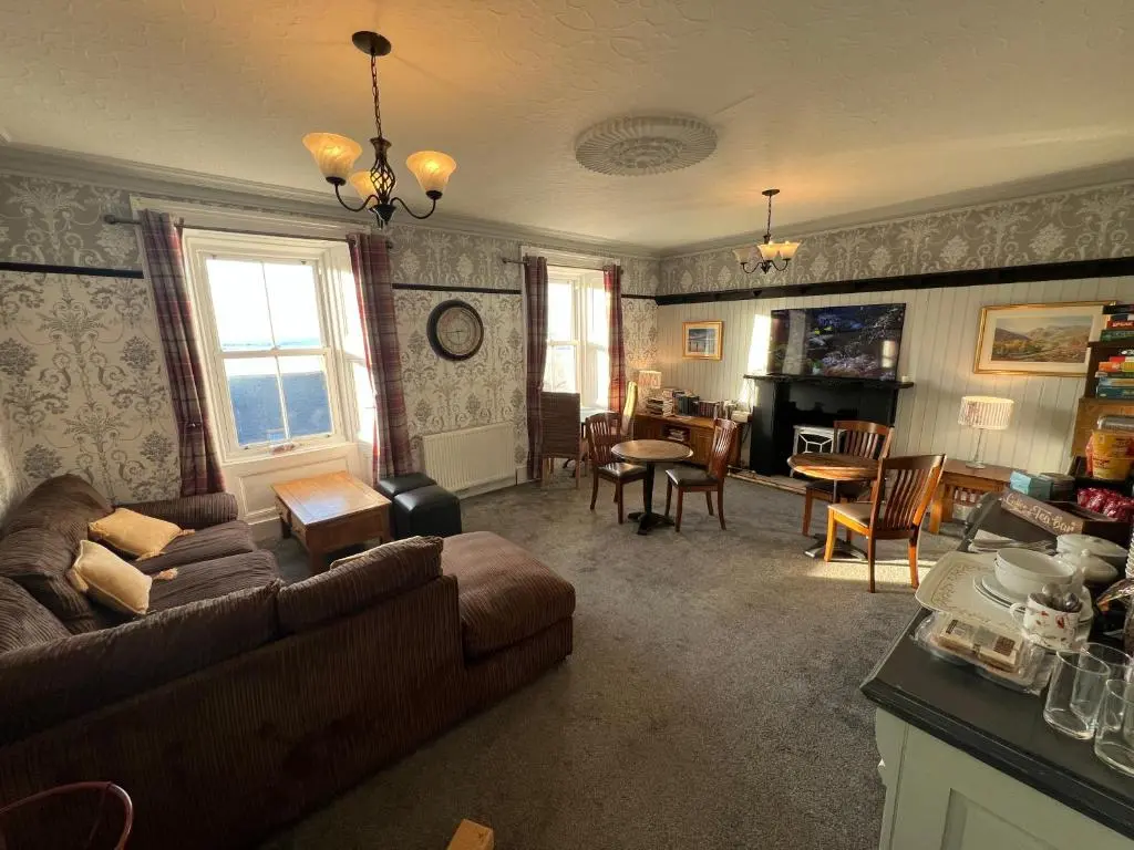 a living room with a couch and a table at The Garden Arms Pub and Rooms in Gardenstown