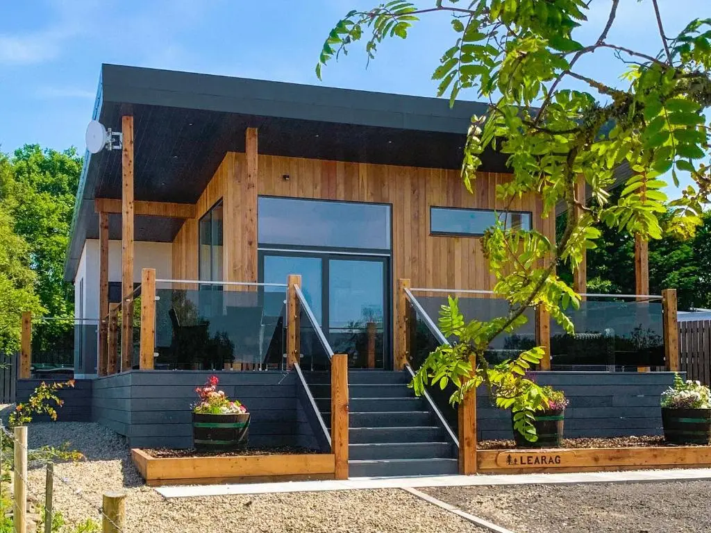 a house with glass doors and stairs in front of it at Learag in Culbokie