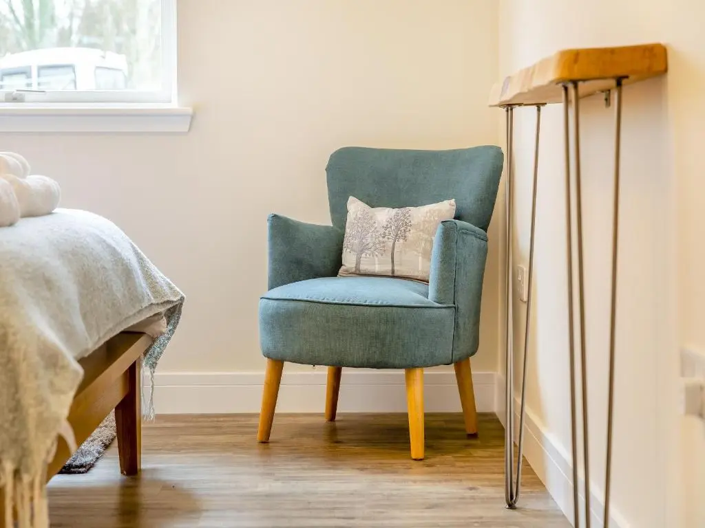 a blue chair sitting in a room next to a bed at Learag in Culbokie