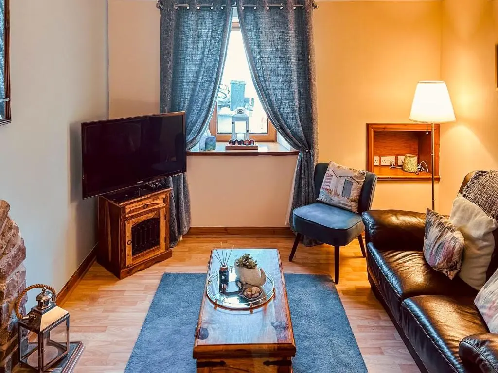 a living room with a couch and a tv at Seahaven Cottage in Portknockie