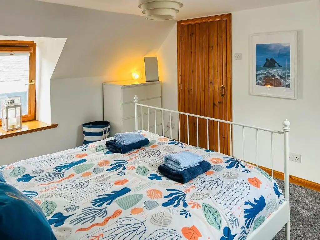 a bedroom with a bed with two pillows on it at Seahaven Cottage in Portknockie