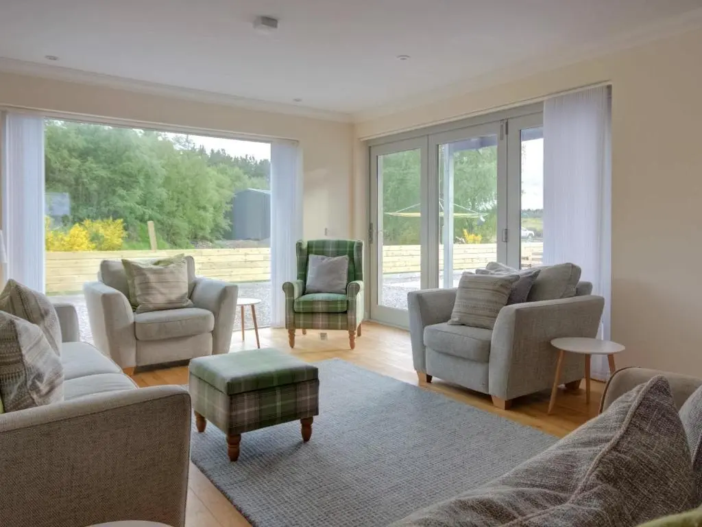 a living room with couches and chairs and a large window at Darna House in Tain