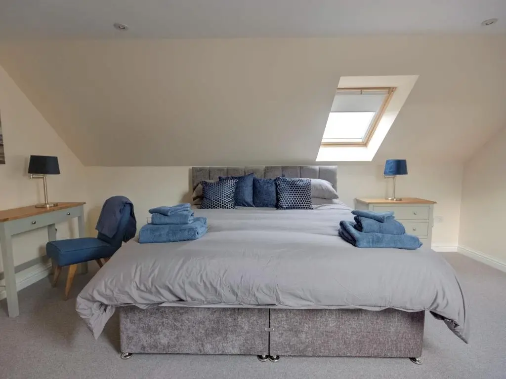 a bedroom with a large bed with blue pillows at Darna House in Tain