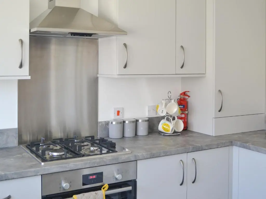 a kitchen with white cabinets and a stove at Faillie in Inverness