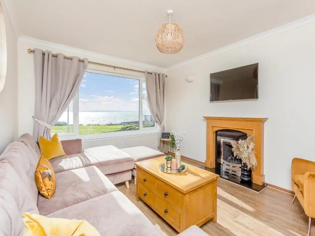 a living room with a couch and a fireplace at Mermaid View in Balintore