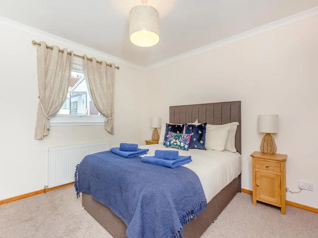 a bedroom with a bed with blue towels on it at Mermaid View in Balintore