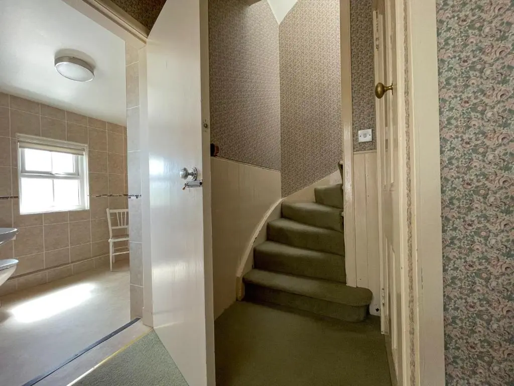 a bathroom with a stairway with a stair case at Pine Cottage - Dalcross in Dalcross