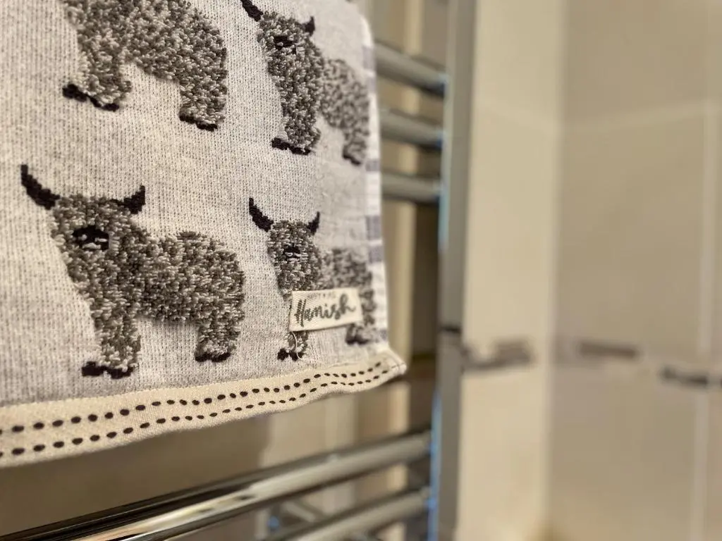 a towel with four llamas on a refrigerator at Pine Cottage - Dalcross in Dalcross