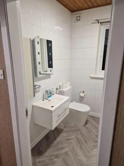 a white bathroom with a sink and a toilet at Catalina - Modern 2 bedroom bungalow in Elgin