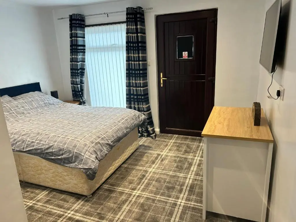 a bedroom with a bed and a television in it at One bed and bathroom with kitchen for self catering Alness in Alness