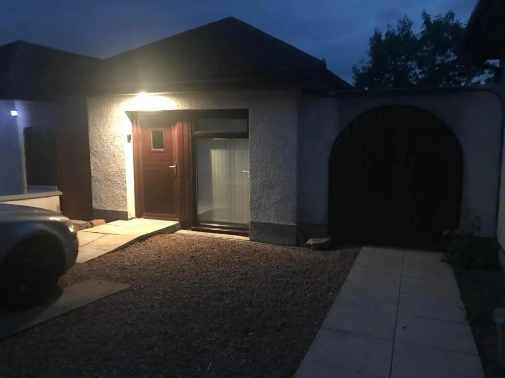 a house with a door with a light on it at One bed and bathroom with kitchen for self catering Alness in Alness