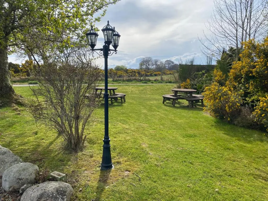 a street light in a park with picnic tables at Carnegie Lodgings, Tain in Tain