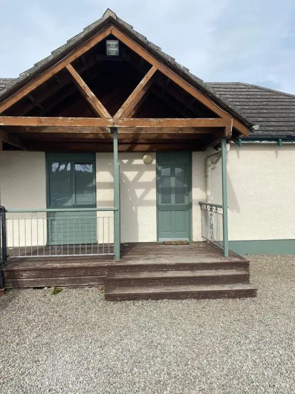 a house with a porch and stairs in front at Carnegie Lodgings, Tain in Tain