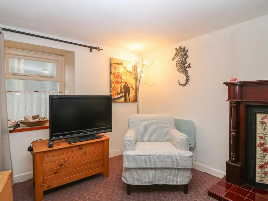 a living room with a tv and a chair at 171 Seatown in Buckie