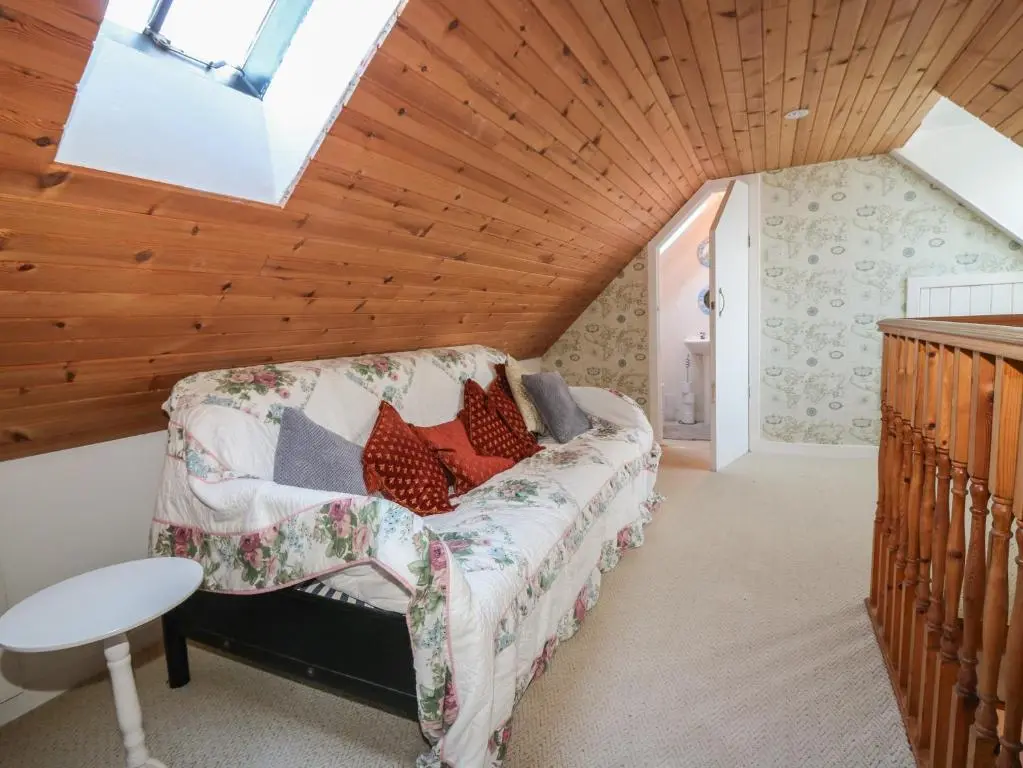 a attic bedroom with a couch and a skylight at 171 Seatown in Buckie
