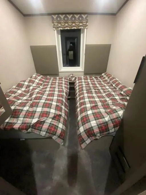 a bed in a room with a plaid blanket at Corrie Fee Lodge in Boat of Garten