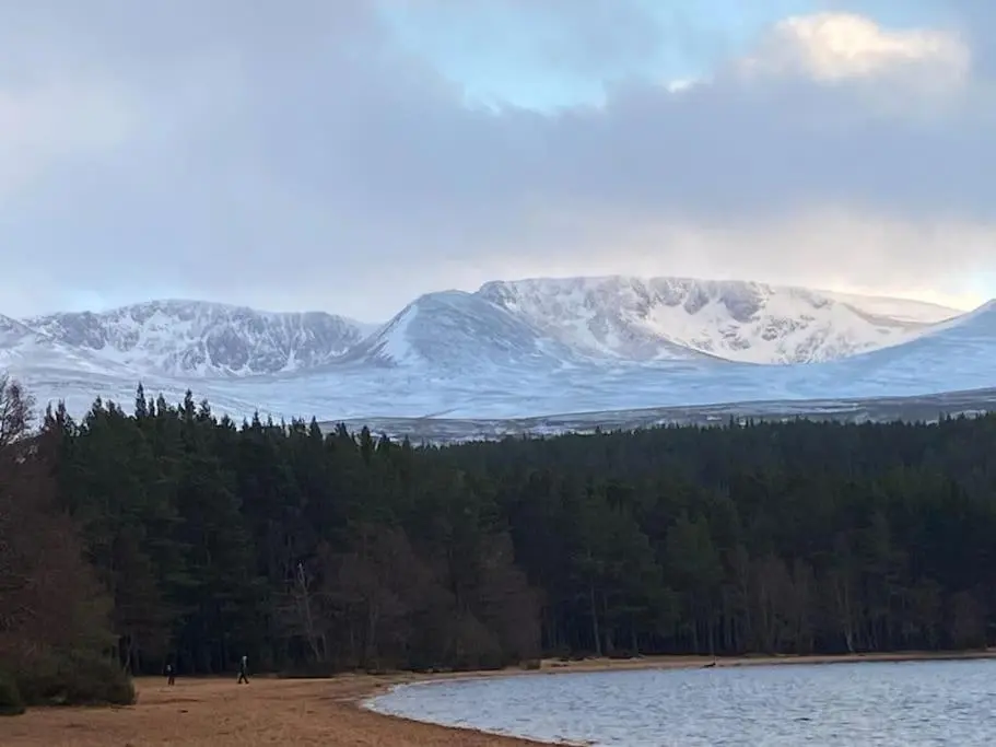 a view of snow covered mountains and a body of water at Corrie Fee Lodge in Boat of Garten