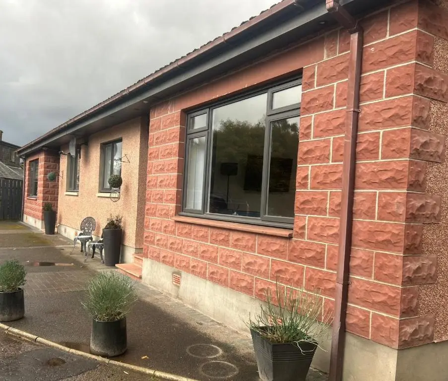 a brick building with a window on the side of it at Balmanach Court in Beauly