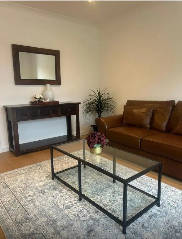 a living room with a couch and a glass coffee table at Balmanach Court in Beauly