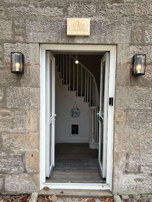 a doorway into a building with a stairway leading into a building at 1 Links Place in Nairn