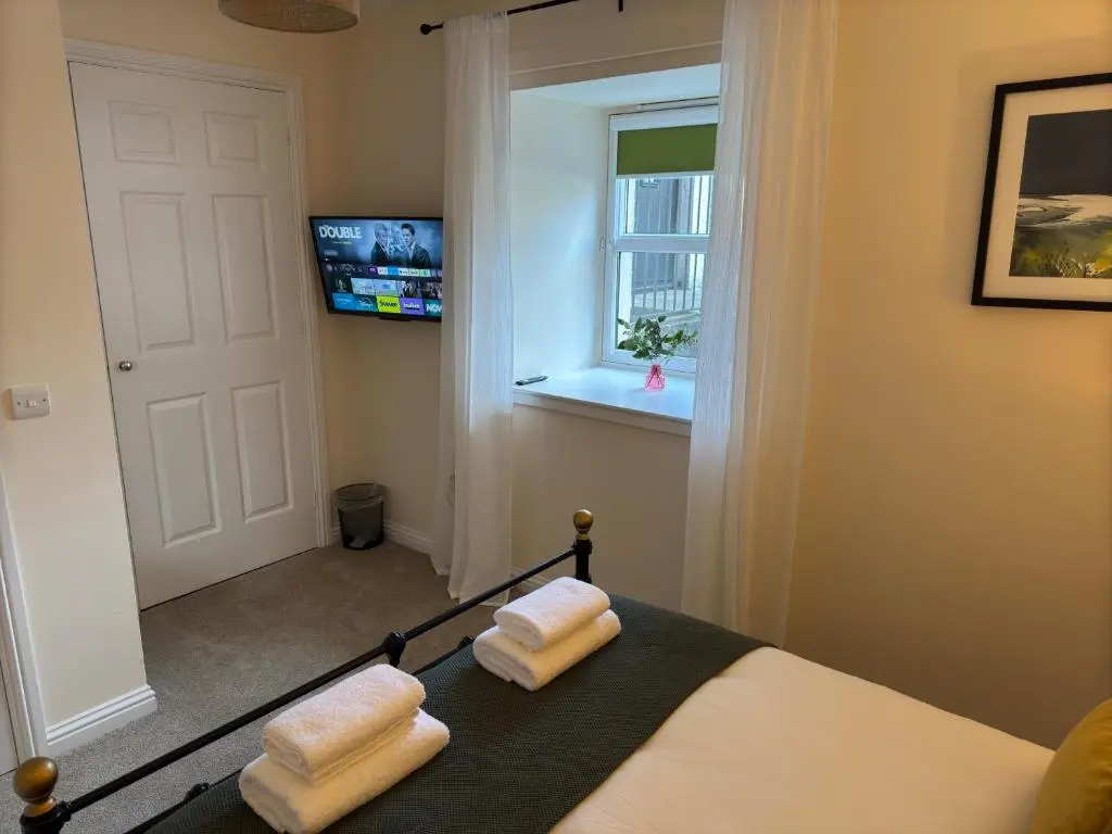 a bedroom with a bed with two white towels at 20a, By The Ness in Inverness