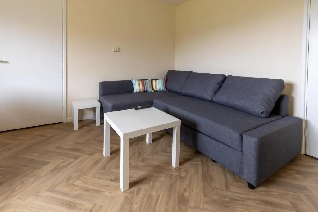 a living room with a blue couch and a table at Wick Bay Apartments in Wick