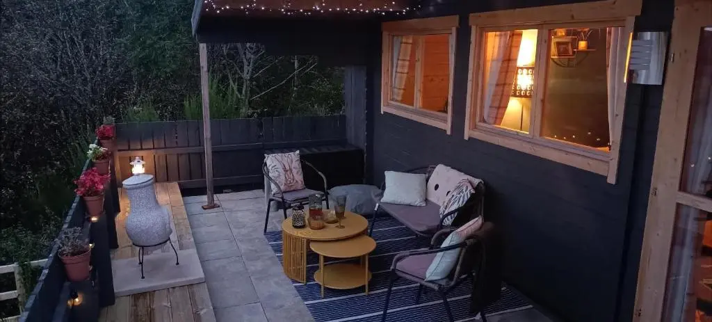 a patio with chairs and a table and a window at Fairvine Cabin Fort Augustus Mtn View Pet Friendly in Fort Augustus